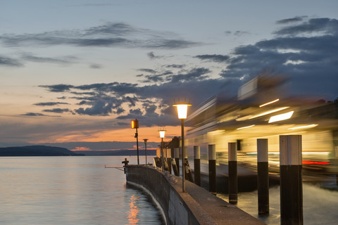 Germany, Baden-Wuerttemberg, Lake Constance, Meersburg, ferry at pier at dusk stock photo