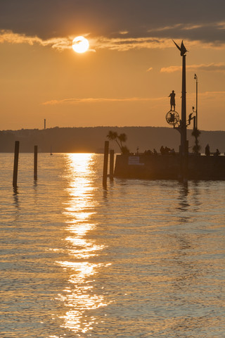 Deutschland, Baden-Württemberg, Bodensee, Meersburg, Hafeneinfahrt mit Skulptur magische Säule bei Sonnenuntergang, lizenzfreies Stockfoto