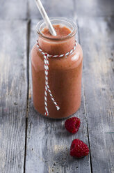 Glass of raspberry smoothie on grey wood - ODF000884