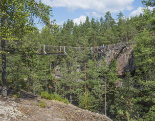Finnland, Südsavoyen, Kymenlaakso, Repovesi-Nationalpark, Junge geht über die Lapinsalmi-Hängebrücke - JBF000167