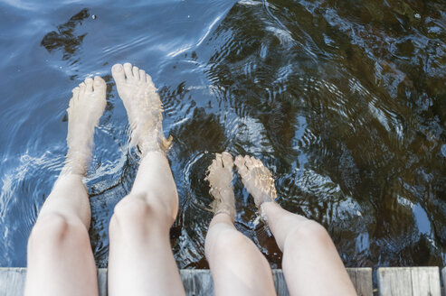 Finnland, Saimaa-See, Kinder planschen mit den Füßen im Wasser - JBF000168