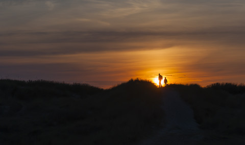 Dänemark, Jütland, Lokken, Mutter und Tochter wandern in der Düne bei Sonnenuntergang, lizenzfreies Stockfoto