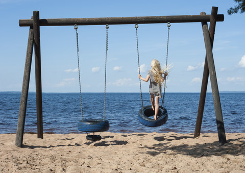 Schweden, Bezirk Vastra Gotaland, See Skagern, Mädchen auf Schaukel, lizenzfreies Stockfoto