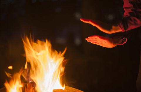 Hände einer Frau am Lagerfeuer erhitzt, lizenzfreies Stockfoto