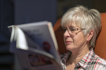 Senior woman reading magazine in the evening - FRF000134