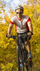 Mann fährt mit dem Mountainbike im herbstlichen Wald - STSF000642