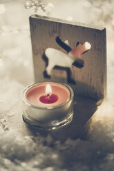 Teelichthalter mit angezündeter roter Kerze auf Kunstschnee - SARF001085
