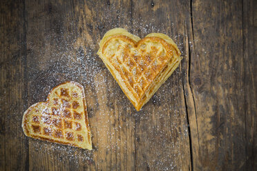 Heart shaped waffles sprinkled with icing sugar on dark wood - LVF002367