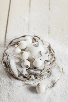 Kranz mit weißen Christbaumkugeln, Stern und Kunstschnee auf Holz - SBDF001483