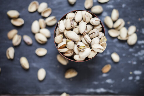 Bowl of roasted and salted pistachios on slate - SBDF001512