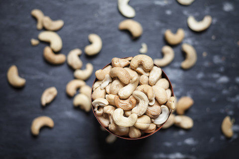 Schale mit gerösteten und gesalzenen Cashewnüssen auf Schiefer, lizenzfreies Stockfoto