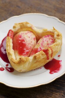 Pear heart tarts with red current sauce on plate - HAWF000521