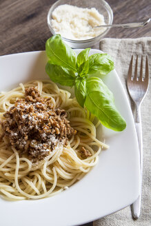 Spaghetti mit Bolognesesauce, Basilikum und Parmesan auf dem Teller - SARF001096