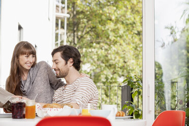 Happy couple at home having breakfast - FMKF001360