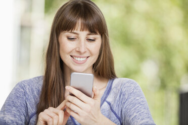 Woman looking at cell phone - FMKF001371