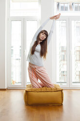 Frau macht Yoga-Übung zu Hause - FMKF001431