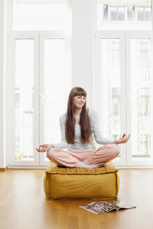 Frau macht Yoga-Übung zu Hause - FMKF001375