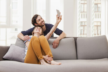 Glückliches Paar nimmt Selfie zu Hause - FMKF001433