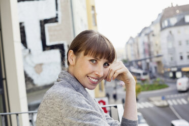 Portrait of smiling woman on balcony - FMKF001410