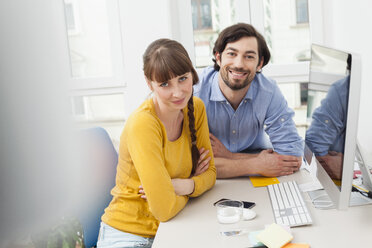 Portrait of smiling couple in home office - FMKF001442