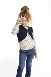 Blond little girl showing victory sign in front of white background - GDF000625