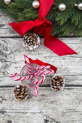 Advent wreath with red bow, fir cones and glass of sugar canes on wood - LVF002395