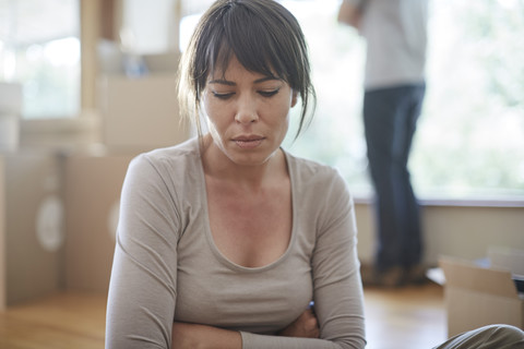 Woman sitting and feeling unhappy during moving house stock photo