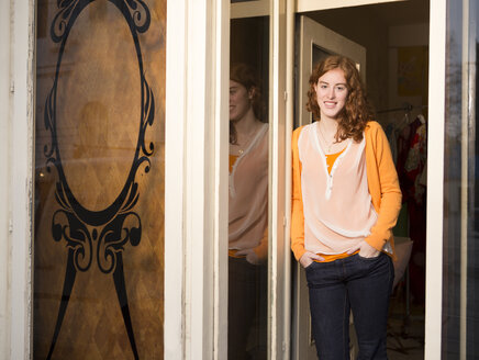 Porträt einer Modedesignerin, die am Eingang ihres Ateliers steht - DISF001107