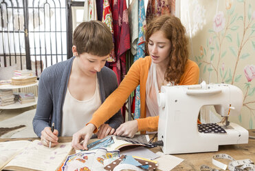 Zwei Modedesignerinnen arbeiten gemeinsam in ihrem Atelier - DISF001128
