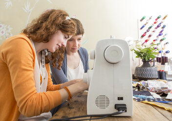 Two female fashion designers working together at their studio - DISF001130