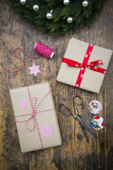 Wrapped Christmas presents and scissors on dark wood - LVF002405