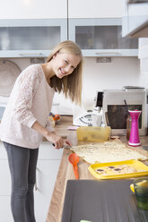 Mädchen bei der Zubereitung von Weihnachtsplätzchen in einer Küche - VTF000363