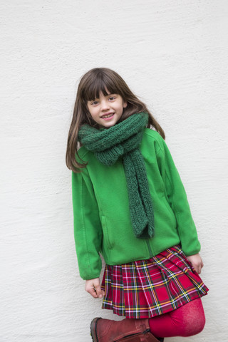 Porträt eines lächelnden Mädchens mit grünem Schal, grüner Jacke und Kilt, lizenzfreies Stockfoto
