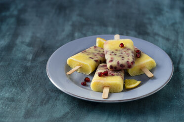 Dish with four orange pomegranate ice lollies - MYF000752