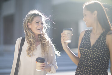 Zwei glückliche Frauen mit Coffee-to-go-Bechern - ZEF001563