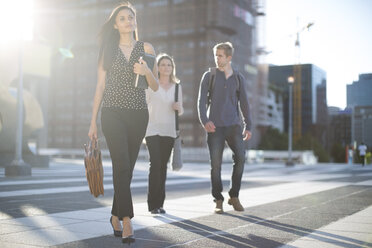 Three people walking on city square - ZEF001568