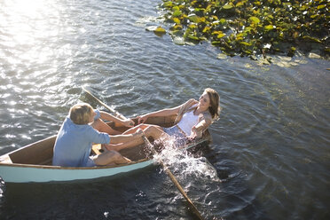 Playful young couple in a rowing boat on a lake - ZEF002333