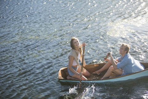 Glückliches junges Paar in einem Ruderboot auf einem See, lizenzfreies Stockfoto