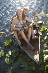 Glückliches junges Paar in einem Ruderboot auf einem See - ZEF002341