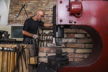 Knife maker in workshop at work - TCF004420