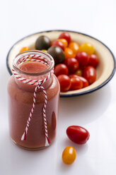 Glass of tomato smoothie and bowl with different mini tomatoes - ODF000908