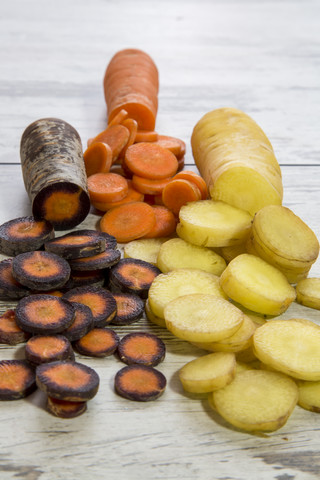 Verschiedene in Scheiben geschnittene Bio-Möhren auf Holz, lizenzfreies Stockfoto