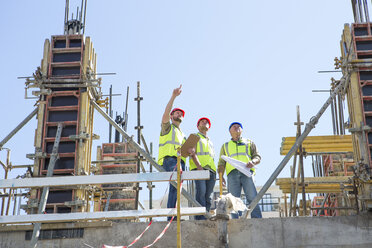 Construction workers discussing building plans in construction site - ZEF001945