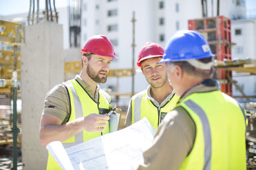 Bauarbeiter besprechen Baupläne auf einer Baustelle - ZEF001586