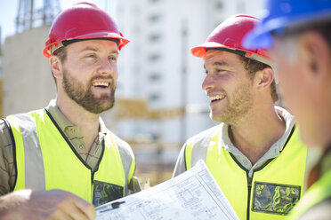 Bauarbeiter besprechen Baupläne auf einer Baustelle - ZEF001590