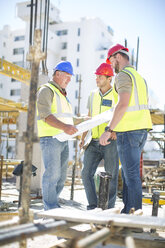 Bauarbeiter besprechen Baupläne auf einer Baustelle - ZEF001581