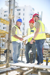 Construction workers discussing building plans in construction site - ZEF001581