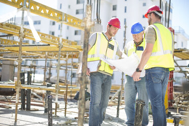 Bauarbeiter besprechen Baupläne auf einer Baustelle - ZEF001582