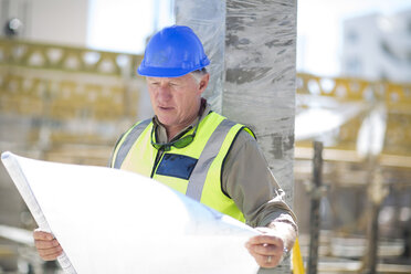 Construction worker reading building plan in construction site - ZEF001598