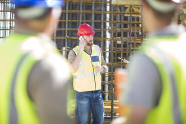 Bauarbeiter telefoniert auf einer Baustelle mit seinem Handy - ZEF001607